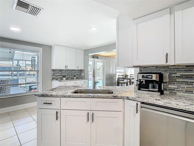 kitchen with visible vents, light tile patterned flooring, a sink, white cabinetry, and dishwasher