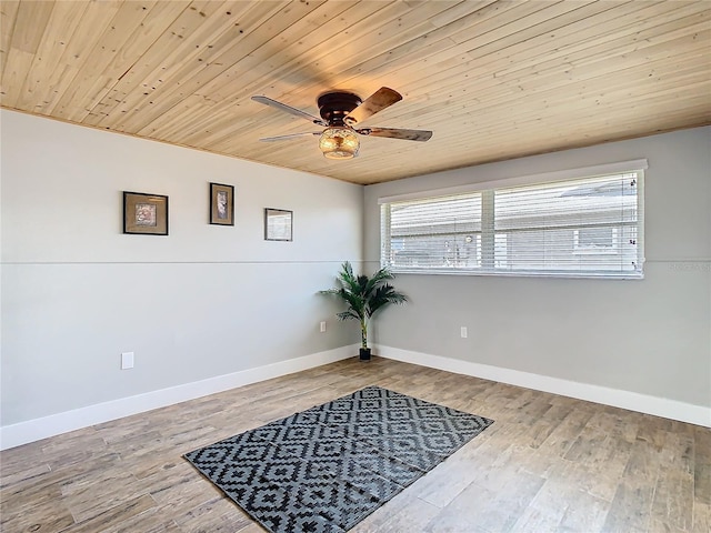 interior space with wooden ceiling, ceiling fan, baseboards, and wood finished floors