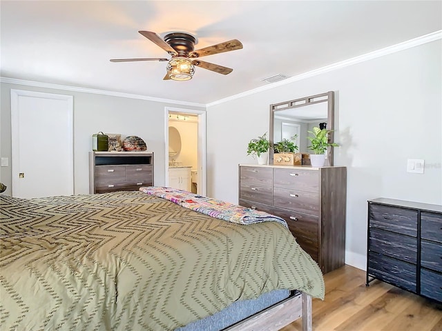 bedroom featuring light wood finished floors, visible vents, ornamental molding, a ceiling fan, and ensuite bath