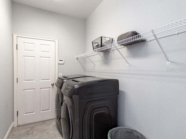 laundry area featuring laundry area, baseboards, and separate washer and dryer