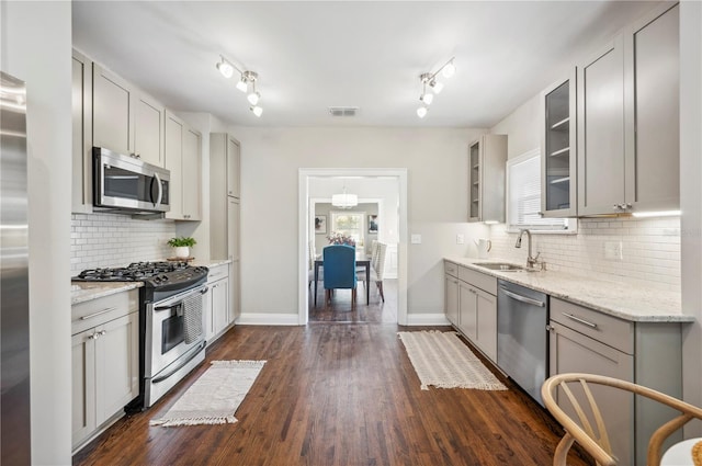 kitchen with stainless steel appliances, gray cabinets, visible vents, glass insert cabinets, and a sink