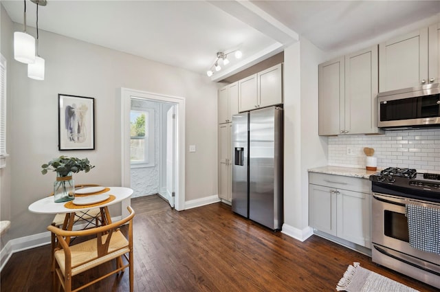 kitchen with dark wood-style floors, stainless steel appliances, tasteful backsplash, light stone countertops, and baseboards