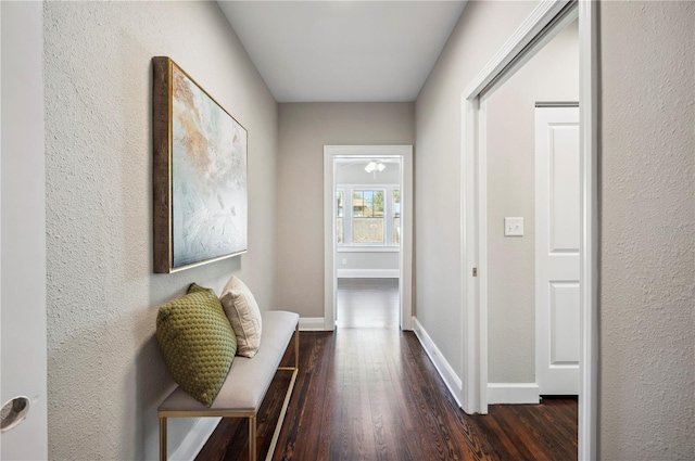 corridor featuring dark wood-style floors and baseboards