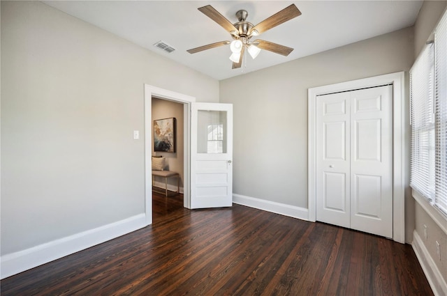 unfurnished bedroom featuring a ceiling fan, a closet, baseboards, and wood finished floors