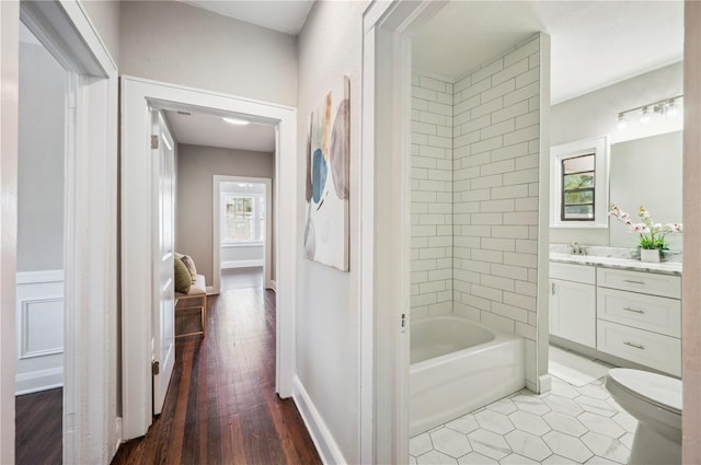 bathroom featuring baseboards, vanity, toilet, and wood finished floors