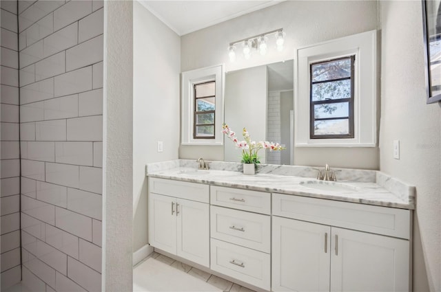 full bath featuring crown molding, tile patterned floors, a sink, and double vanity