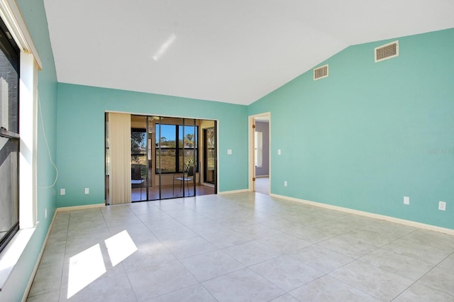 unfurnished room featuring baseboards, visible vents, vaulted ceiling, and tile patterned floors