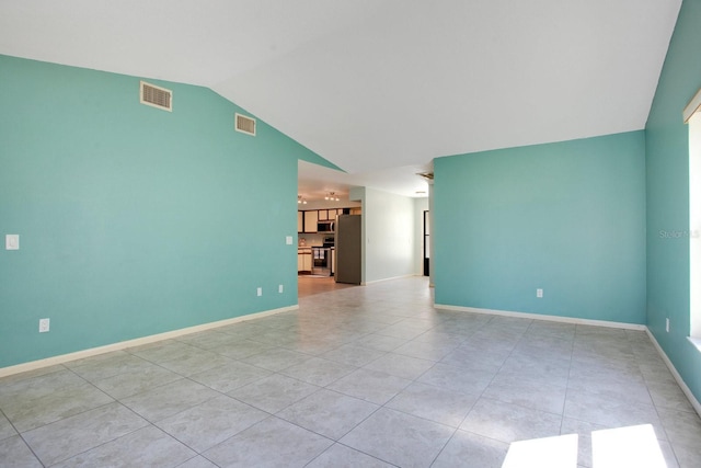 spare room with lofted ceiling, visible vents, baseboards, and light tile patterned flooring