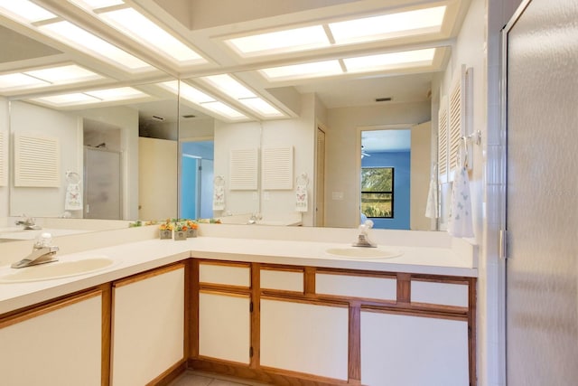 full bathroom with visible vents, a sink, a shower stall, and double vanity