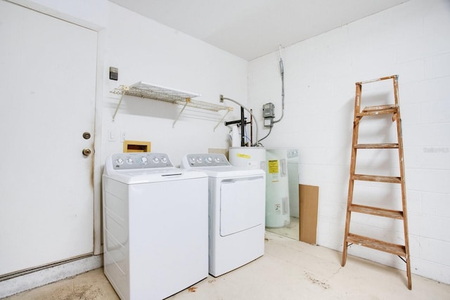 clothes washing area with concrete block wall, laundry area, water heater, and washer and clothes dryer