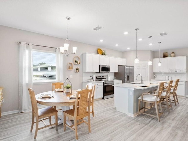 dining room with light wood-style flooring, visible vents, a chandelier, and recessed lighting