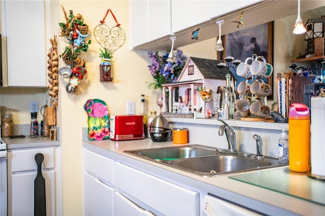 kitchen featuring light countertops, a sink, and white cabinets