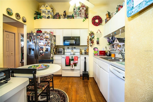 kitchen featuring white cabinets, white appliances, dark wood finished floors, and a sink