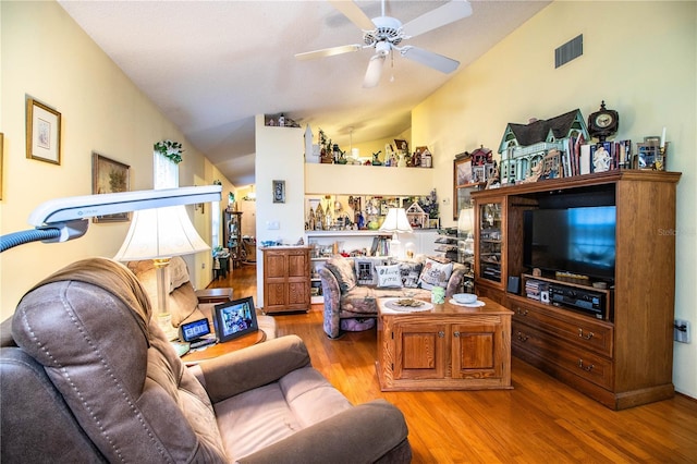 living room with lofted ceiling, light wood-style floors, and a ceiling fan