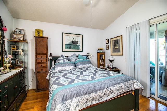 bedroom featuring vaulted ceiling, dark wood-type flooring, and access to exterior