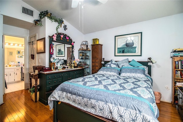 bedroom with lofted ceiling, ceiling fan, ensuite bathroom, hardwood / wood-style flooring, and visible vents