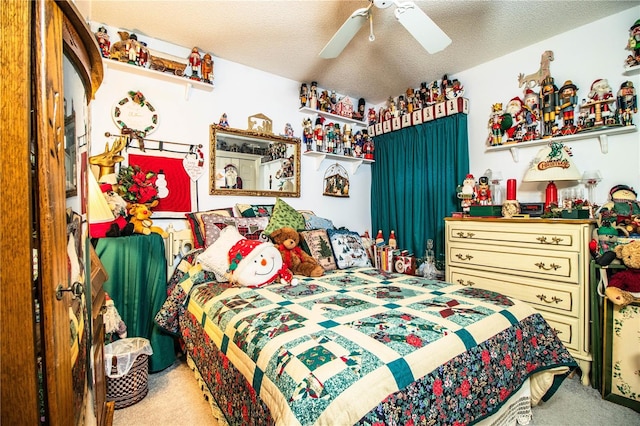 bedroom featuring a ceiling fan, carpet, and a textured ceiling