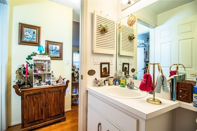 bathroom with wood finished floors and vanity