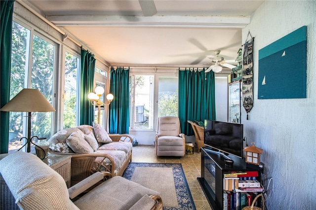 sunroom / solarium featuring ceiling fan and beamed ceiling