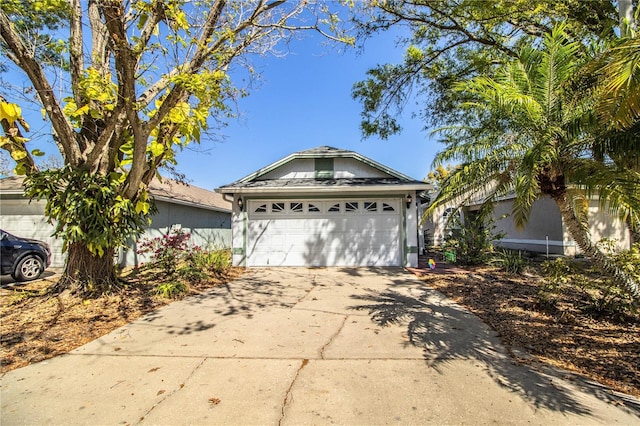 single story home featuring concrete driveway and an attached garage