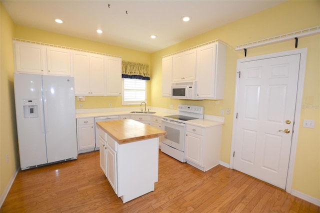 kitchen with white appliances, butcher block counters, light wood-style flooring, and white cabinets