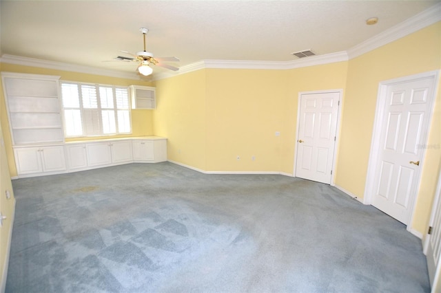 empty room with carpet flooring, a ceiling fan, baseboards, visible vents, and crown molding