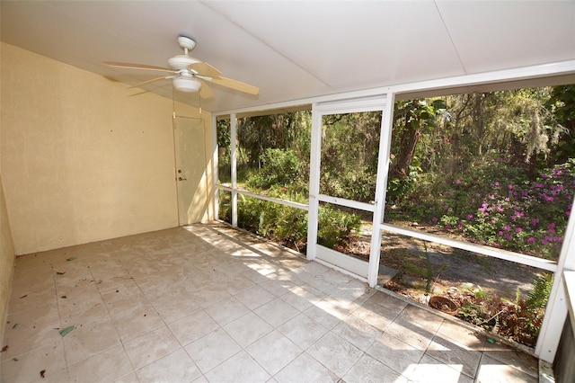 unfurnished sunroom featuring a ceiling fan