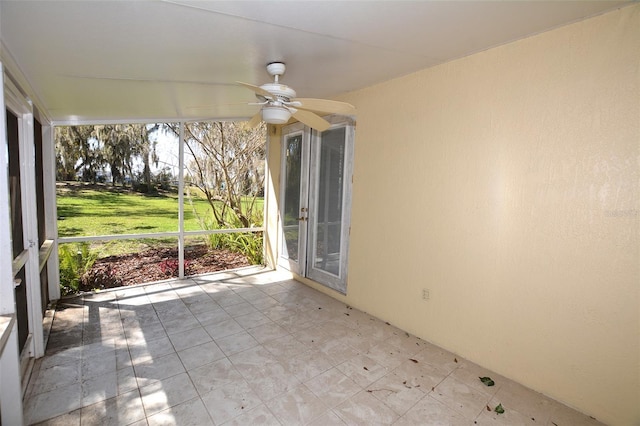 unfurnished sunroom featuring ceiling fan