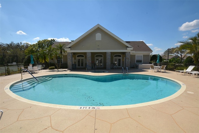 pool with french doors, a patio area, and fence