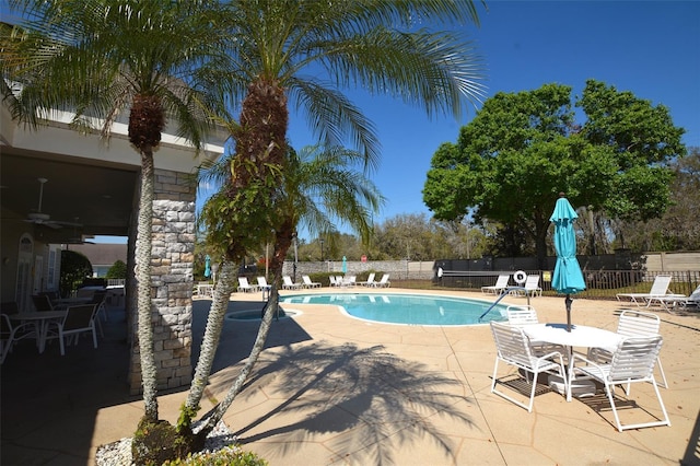 pool with ceiling fan, a patio, and fence