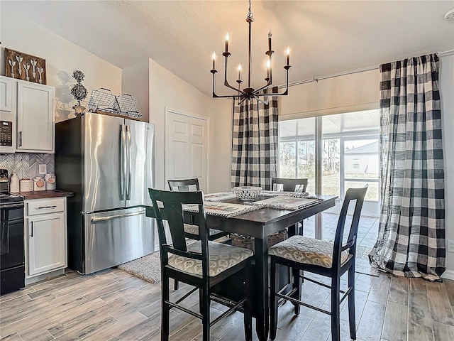 dining room featuring light wood-type flooring and a notable chandelier