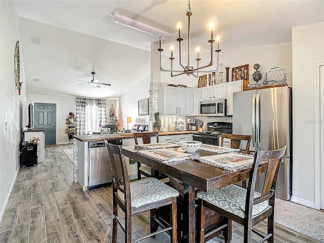 kitchen with visible vents, light wood-type flooring, lofted ceiling, stainless steel appliances, and white cabinetry