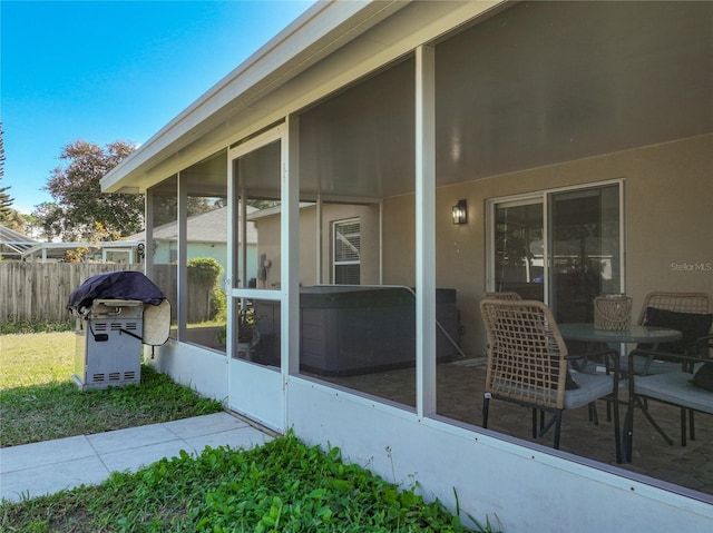 view of patio / terrace featuring grilling area, fence, and a sunroom