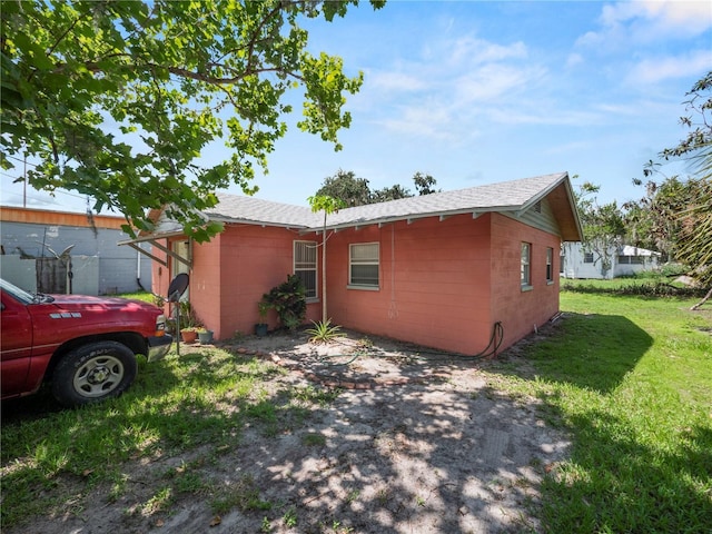 view of side of home featuring concrete block siding and a lawn