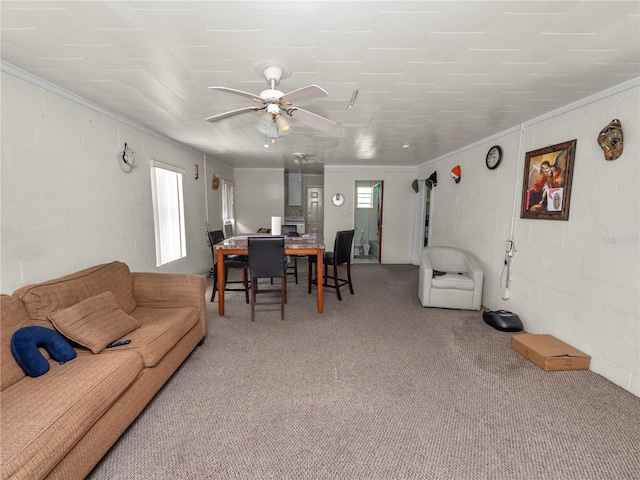 carpeted living area featuring a ceiling fan and crown molding