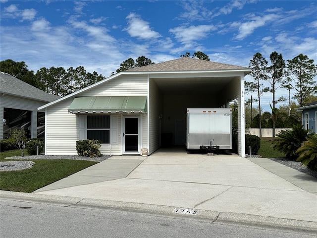 view of front of home with roof with shingles and driveway