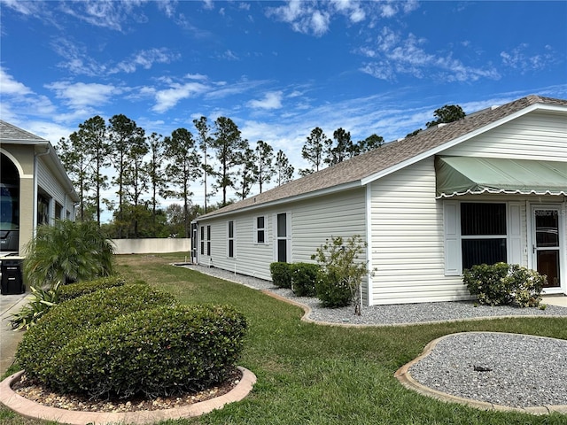 view of side of home with a yard