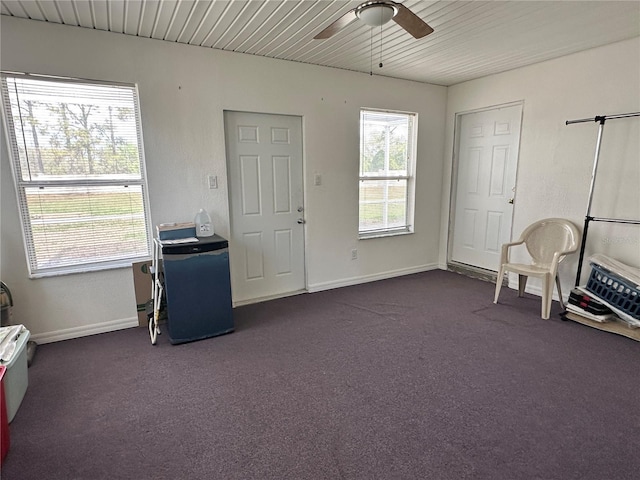 unfurnished room featuring wood ceiling, ceiling fan, baseboards, and dark colored carpet