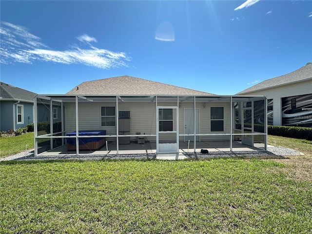 rear view of property with roof with shingles, a yard, a patio, a hot tub, and glass enclosure