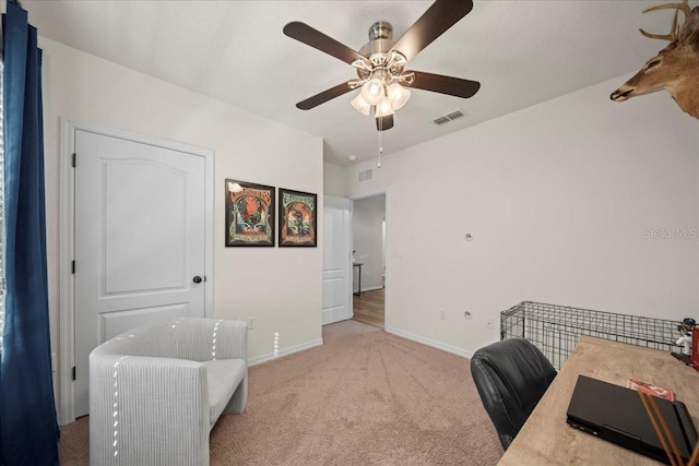 carpeted office space featuring a ceiling fan, visible vents, and baseboards