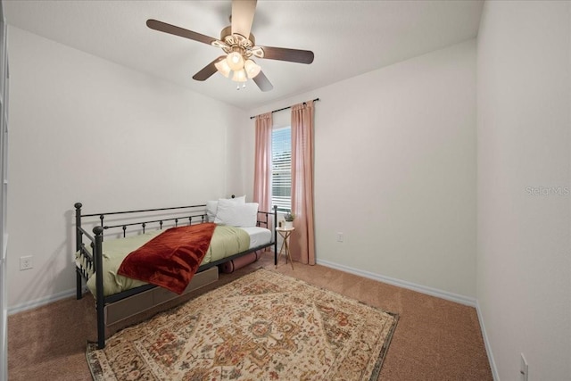 bedroom with ceiling fan, baseboards, and carpet flooring