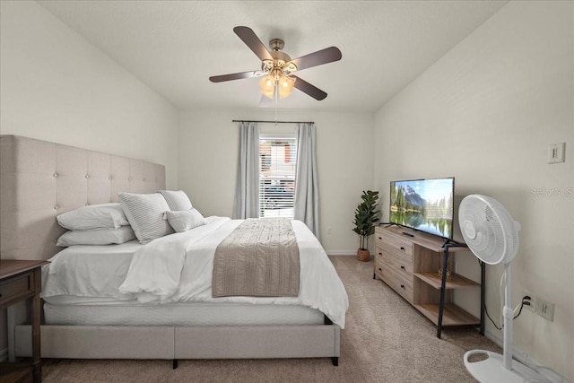 bedroom featuring light carpet, a ceiling fan, and baseboards