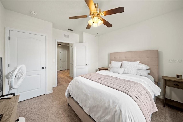 bedroom with light carpet, ceiling fan, and visible vents