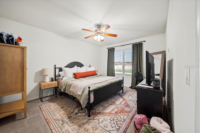 carpeted bedroom featuring a ceiling fan, a textured ceiling, and baseboards