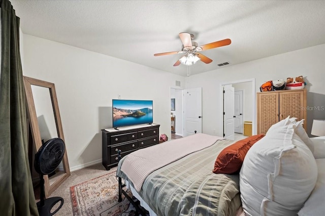 bedroom featuring a textured ceiling, ceiling fan, light colored carpet, visible vents, and baseboards