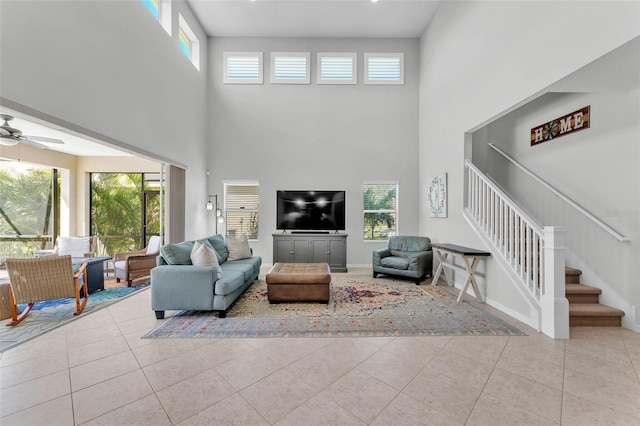 tiled living room with baseboards, stairway, and a ceiling fan