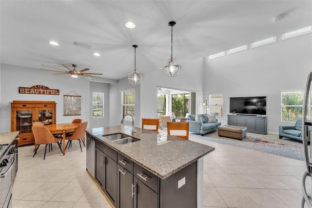 kitchen with light tile patterned floors, open floor plan, and a sink