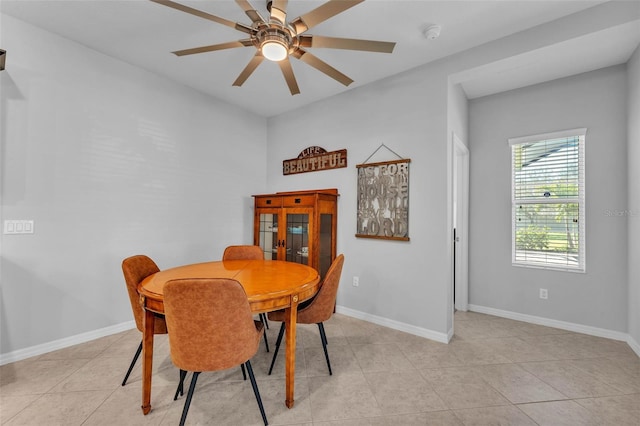 dining room with baseboards, a ceiling fan, and light tile patterned flooring