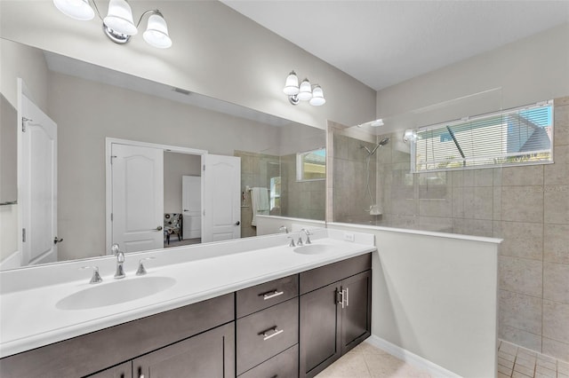 full bathroom with double vanity, walk in shower, a sink, and tile patterned floors