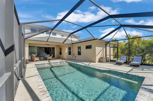 pool featuring a lanai, a patio area, an outdoor hangout area, and a ceiling fan